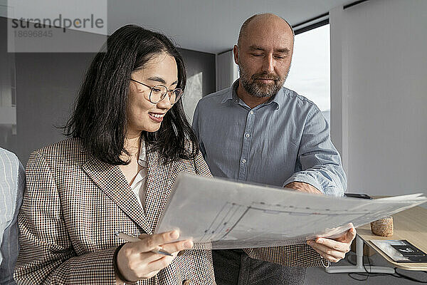 Geschäftsmann und Geschäftsfrau arbeiten gemeinsam an einem Architekturprojekt im Büro