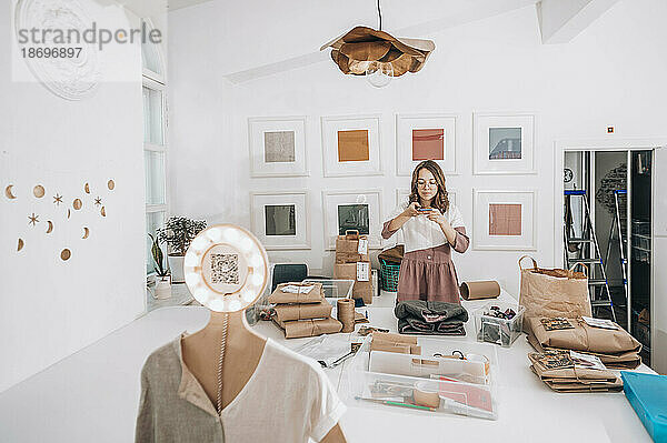 Modedesigner fotografiert Produkte in der Werkstatt