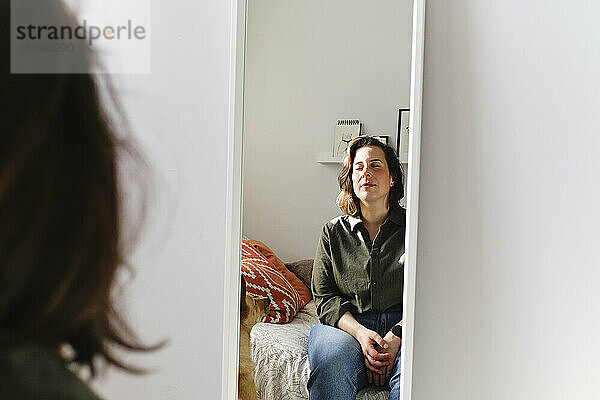 Spiegelbild einer Frau im Spiegel an der Wand zu Hause