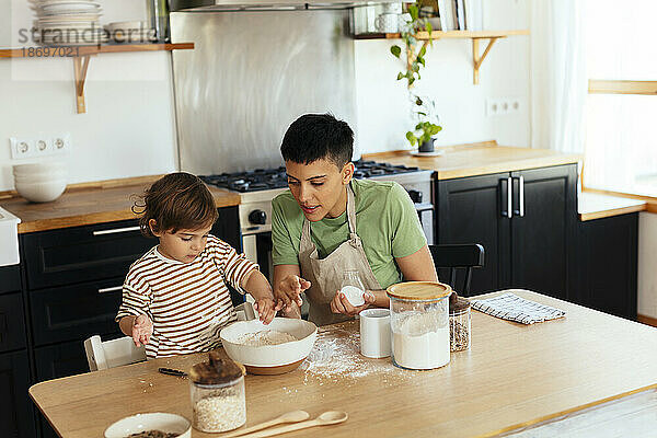 Mutter und Sohn bereiten zu Hause in der Küche Essen zu