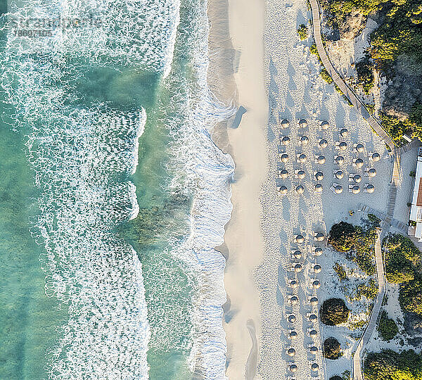 Spanien  Balearen  Formentera  Drohnenansicht von Sonnenschirmreihen am leeren Strand