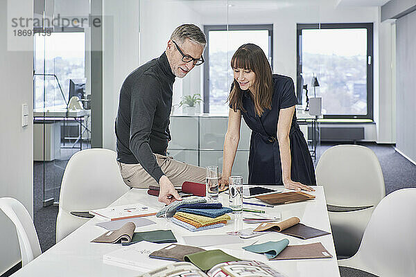 Kreativer Geschäftsmann und Geschäftsfrau diskutieren im Büro über Farbfelder