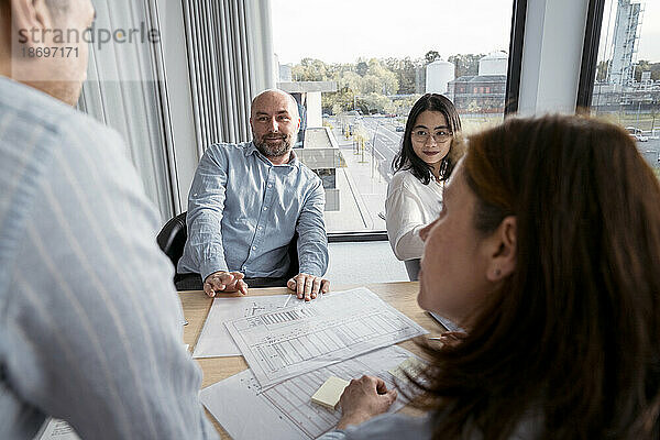 Geschäftsleute arbeiten gemeinsam an einem Architekturprojekt im Büro