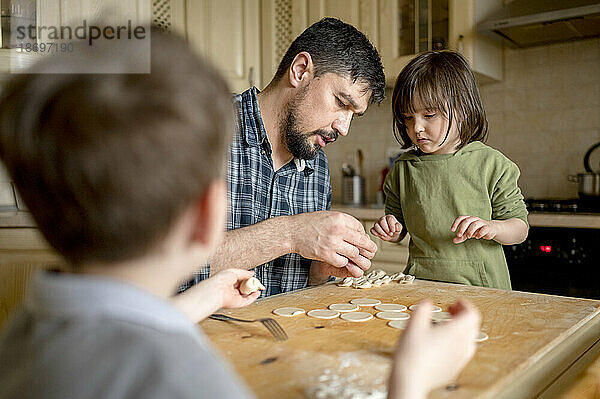 Vater bringt Kindern bei  in der Küche Knödel zu machen
