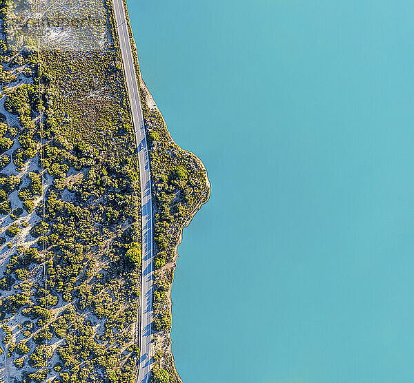 Spanien  Balearen  Formentera  Drohnenansicht einer leeren Straße  die sich entlang der türkisfarbenen Küste erstreckt