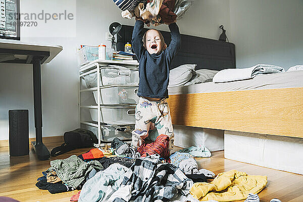 Sorgloser Junge wirft zu Hause Wäschewäsche ins Schlafzimmer