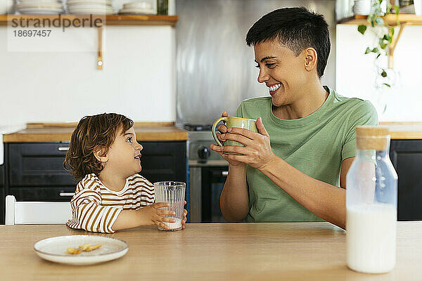 Lächelnde Frau  die zu Hause mit ihrem Sohn frühstückt