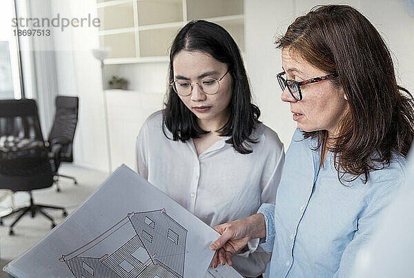 Zwei Geschäftsfrauen arbeiten gemeinsam an einem Architekturprojekt im Büro