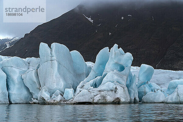 Nahaufnahme der Eisberge und blauen Eisformationen des Fjallsjökull-Gletschers von der Fjallsarlon-Gletscherlagune aus gesehen  am südlichen Ende des berühmten isländischen Gletschers Vatnajökull im Süden Islands; Südisland  Island