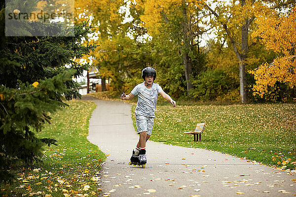 Teenager beim Inlineskaten in einem Stadtpark an einem warmen Herbsttag; St. Albert  Alberta  Kanada