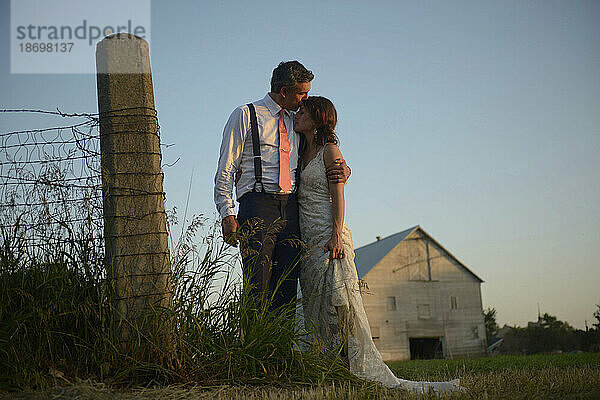 Frischvermähltes Paar umarmt sich auf einem Bauernhof; Genua  Nebraska  Vereinigte Staaten von Amerika