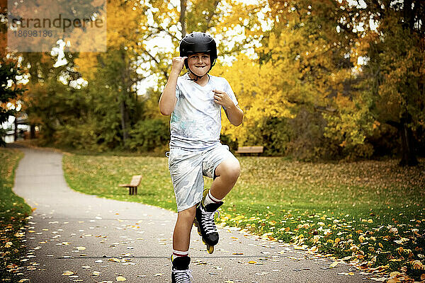 Teenager beim Inlineskaten in einem Stadtpark an einem warmen Herbsttag; St. Albert  Alberta  Kanada