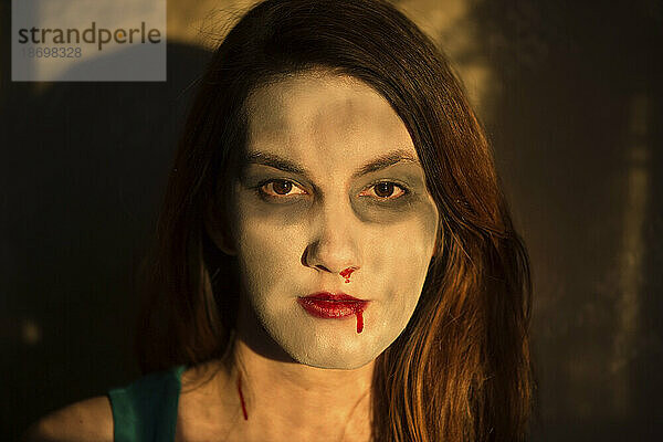 Künstliches Blut strömt aus Mund und Nase einer Frau mit zombieartigem Make-up; Lincoln  Nebraska  Vereinigte Staaten von Amerika