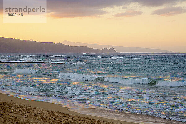Wellen brechen am Ufer des Baldwin Beach an der Nordküste von Maui in der Nähe von Paia bei Sonnenuntergang; Maui  Hawaii  Vereinigte Staaten von Amerika