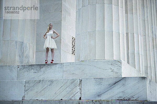 Teenager-Mädchen posiert in formeller Kleidung neben einer großen Säule am Lincoln Memorial in Washington DC  USA; Washington  District of Columbia  Vereinigte Staaten von Amerika