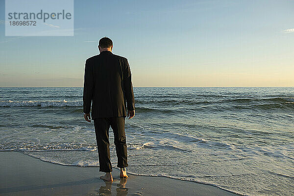 Mann im Anzug geht ins Meer; Panama City Beach  Florida  Vereinigte Staaten von Amerika
