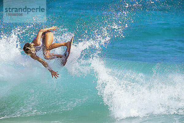 Skimboarder reitet auf einer Meereswelle; Sandstrand  Oahu  Hawaii  Vereinigte Staaten von Amerika