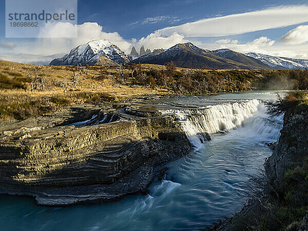 Scenic view of Cascada Rio Paine with the Cuernos Del Paine mountain peaks in the distance; Torres del Paine National Park  Patagonia  Chile