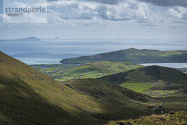 Malerische Aussicht auf den Conor Pass und bergiges Ackerland mit Blick auf Dingle und Skellig Michael am Atlantischen Ozean; Grafschaft Kerry  Irland