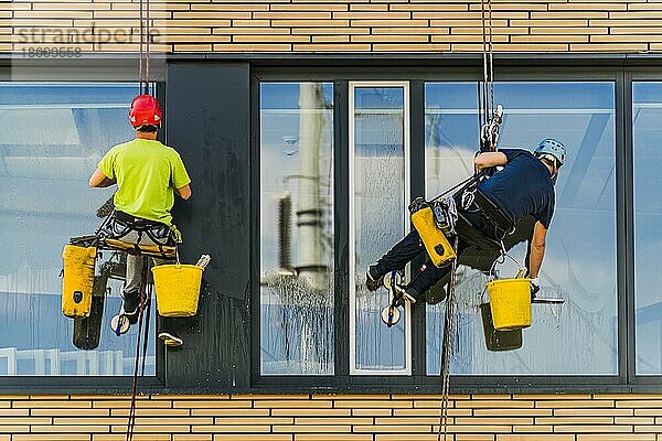 Zwei Männer putzen Fenster in einem Bürogebäude