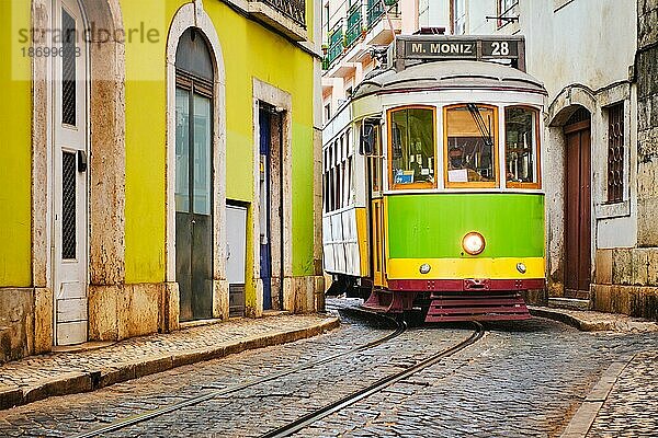 Berühmte alte gelbe Straßenbahn 28 in den engen Straßen des Alfamaviertels in Lissabon  Portugal  Symbol von Lissabon  berühmtes beliebtes Reiseziel und Touristenattraktion  Europa