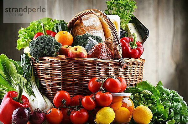 Weidenkorb mit verschiedenen Lebensmitteln  darunter frisches Gemüse und Obst