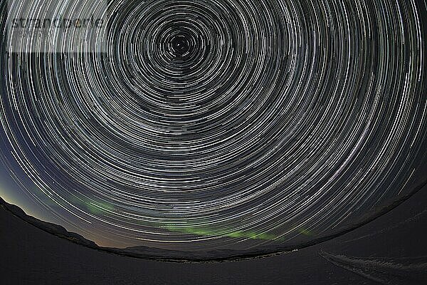 Sternenbahnen (Star trails) mit schwachem Nordlicht über dem See Torneträsk  Abisko  Schweden  Europa