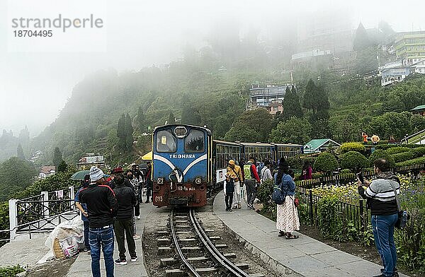 Touristen fahren in einem Spielzeugeisenbahnzug der Darjeeling Himalayan Railway (DHR)  am 25. Mai 2023 in Darjeeling  Indien. Die Darjeeling Himalayan Railway (DHR) ist ein UNESCO Weltkulturerbe  DARJEELING  INDIEN  25. MAI