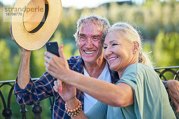 Glückliches älteres Paar  das Selfie auf dem Balkon macht