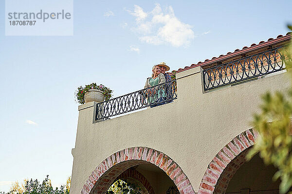 Glückliches  liebevolles älteres Paar  das sich auf dem Balkon der Sommervilla umarmt