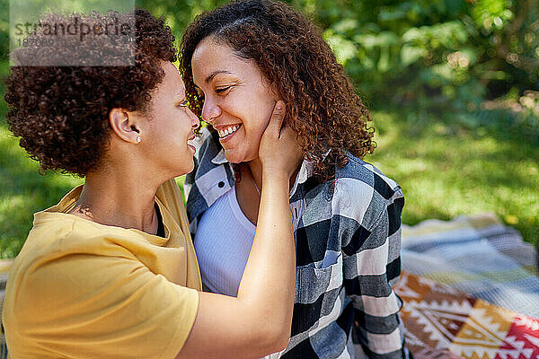 Glückliches  liebevolles lesbisches Paar  das sich im Park von Angesicht zu Angesicht umarmt