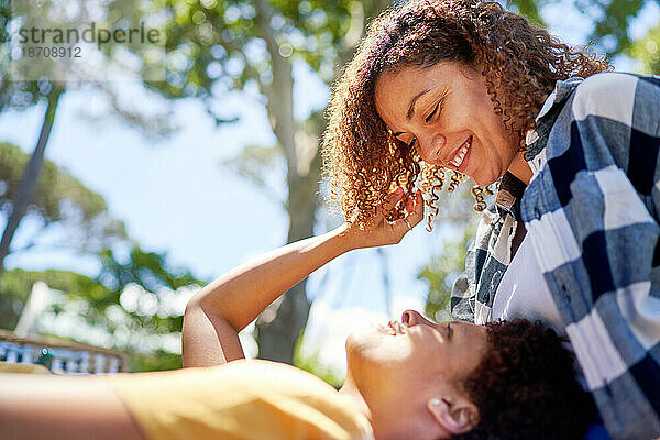 Glückliches lesbisches Paar beim Kuscheln im sonnigen Sommerpark