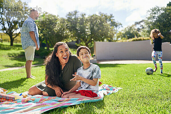 Porträt einer glücklichen Mutter und ihres Sohnes mit Down-Syndrom im sonnigen Park