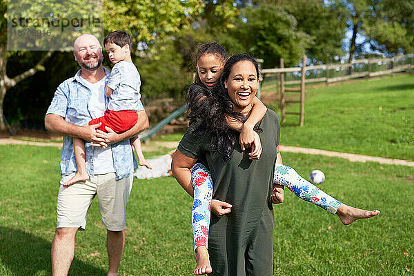 Porträt einer glücklichen  unbeschwerten Familie im sonnigen Sommerpark