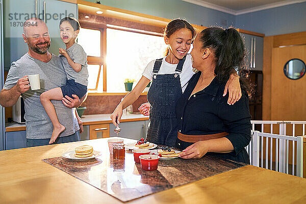 Glückliche Familie  die in der Morgenküche Pfannkuchen isst