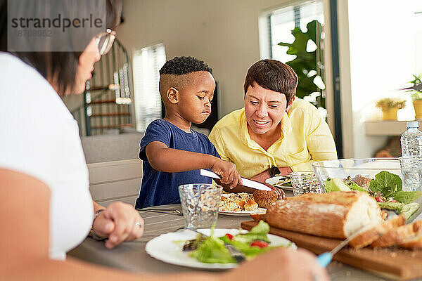 Lesbisches Paar und Sohn essen zu Hause am Esstisch zu Abend
