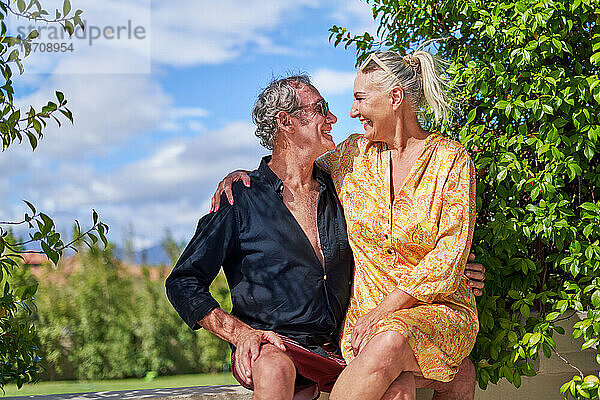 Glückliches  unbeschwertes älteres Paar  das sich auf der Sommerterrasse umarmt