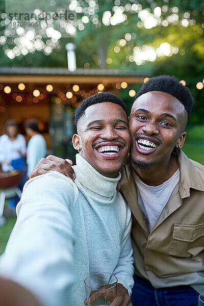 Selfie POV-Porträt glückliches junges schwules männliches Paar  das im Hinterhof lacht