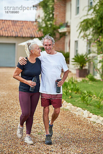 Glückliches  aktives älteres Paar  das vor der Sommervilla spaziert