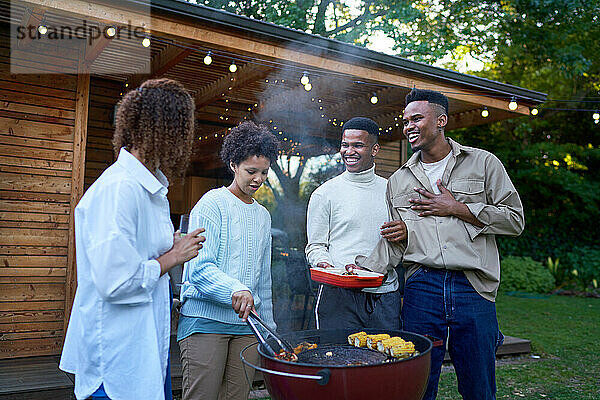 Lesbische und schwule männliche Paare genießen Grillabende im sommerlichen Hinterhof