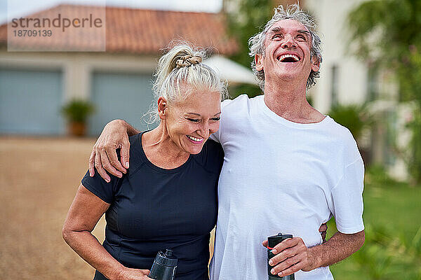 Fröhliches  unbeschwertes Seniorenpaar mit lachenden Wasserflaschen