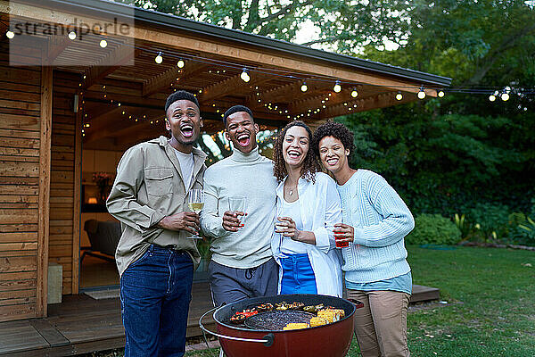 Porträt glücklicher schwuler Paare  die im Sommer im Hinterhof trinken und grillen