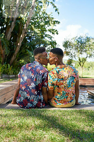Zärtliches junges schwules Männerpaar küsst sich im Schwimmbad