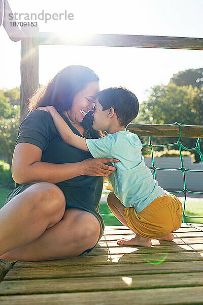 Glückliche Mutter und Sohn am sonnigen Spielplatz