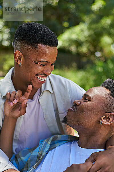 Glückliches  liebevolles junges schwules männliches Paar  das lacht und sich umarmt