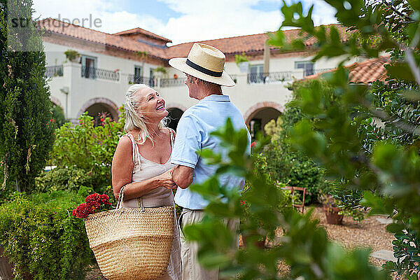 Glückliches  liebevolles älteres Paar  das sich im Garten der Villa unterhält