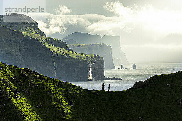Silhouette von Wanderern  die Klippen bewundern  die auf einem Bergrücken über dem Meer stehen  Insel Kalsoy  Färöer-Inseln  Dänemark  Europa
