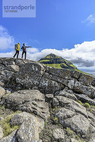 Touristen blicken auf den Fjord während einer Wanderung zum Berg Skaelingsfjall im Sommer  Insel Streymoy  Färöer  Dänemark  Europa