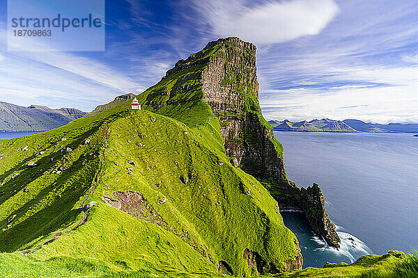 Kallur-Leuchtturm auf mit Gras bedeckten Klippen mit Borgarin-Berggipfel im Hintergrund  Insel Kalsoy  Färöer-Inseln  Dänemark  Europa