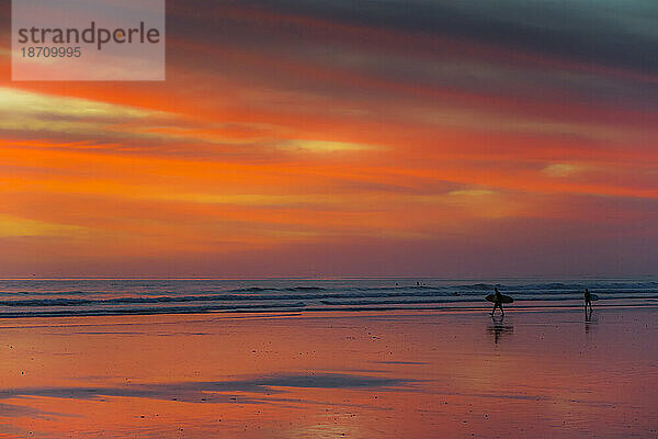 Silhouette eines Surfers am Strand von Guiones  wo viele zum Entspannen und Surfen bei Sonnenuntergang kommen  Playa Guiones  Nosara  Guanacaste  Costa Rica  Mittelamerika